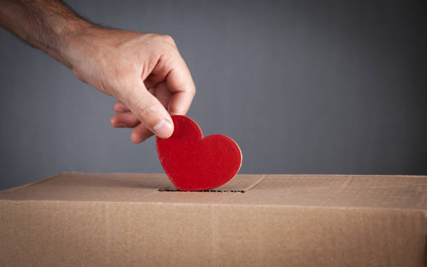 istock Male hand putting red heart in box. 1414599055