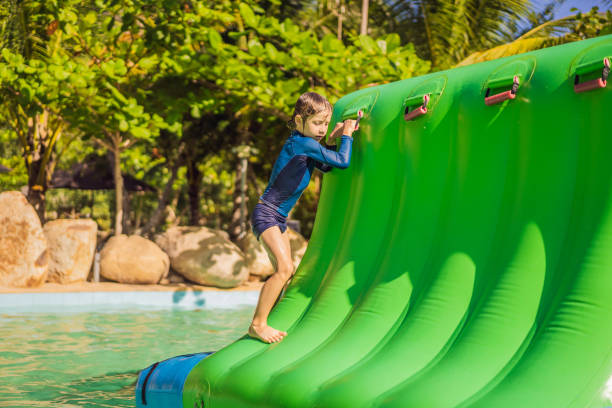 istock Cute boy runs an inflatable obstacle course in the pool 1414599142