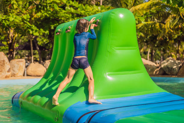 istock Cute boy runs an inflatable obstacle course in the pool 1414599146