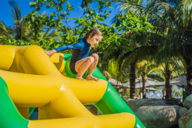 istock Cute boy runs an inflatable obstacle course in the pool 1414599169