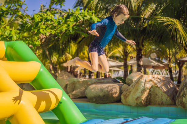 istock Cute boy runs an inflatable obstacle course in the pool 1414599176