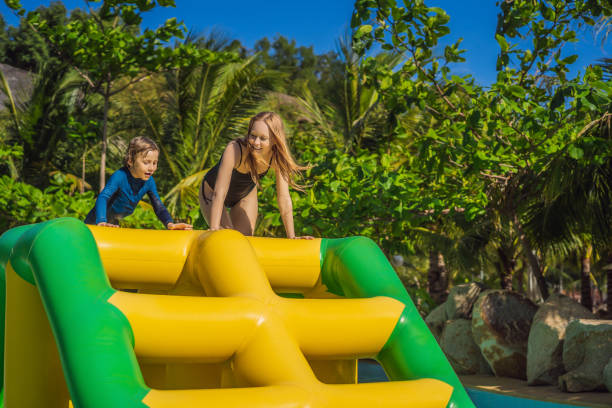 istock Mother and son go through an inflatable obstacle course in the pool 1414599177