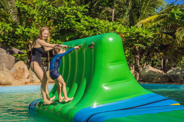 istock Mother and son go through an inflatable obstacle course in the pool 1414599178