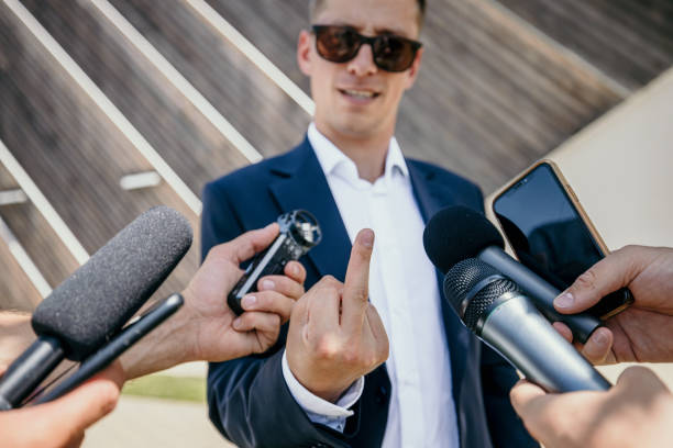 istock Spokesperson doing obscene gesture while talking to journalists in interview 1414602531