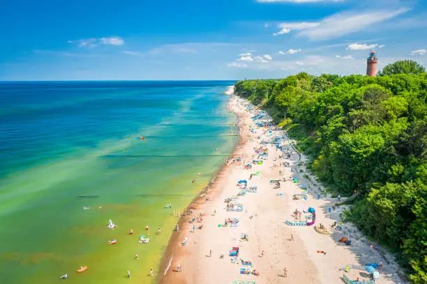Crowded beach with people at Baltic Sea. Tourism on sea in Poland. Aerial view of nature