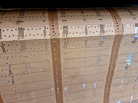 Punch Card, used in the past before computers made this job. The close-up image shows a punch card used in a embroidery factory.
