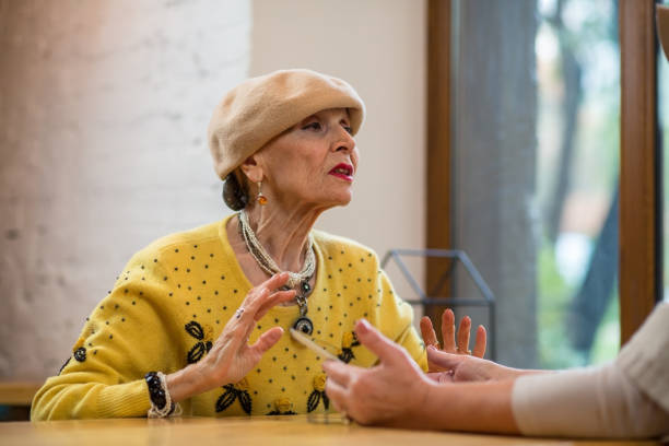 istock Elderly woman talking at table. 1414605020