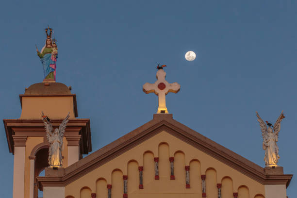 the moon and toucans perched on the Catholic Church of Nossa Senhora da Abadia in Uberaba, Minas Gerais