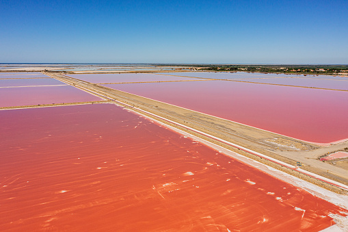 Scenic view of beautiful pink salt lake against blue sky during sunny day