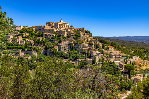 Beautiful view of idyllic village Castel del Monte, set into a steep hillside under apennine mountain peaks on a sunny summer day, Gran Sasso e Monti della Laga National Park, L'Aquila, Abruzzo, Italy