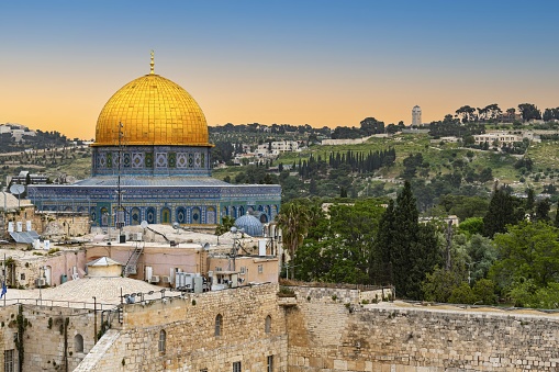East Jerusalem, Palestine, May 3, 2019: View of the golden cupola of the Dome of the Rock on the Temple Mount. On the horizon on the Mount of the Olives is the tower of the protestant Ascension Church.
