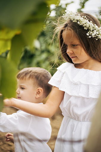 White T-shirt andmdresses, all in amazing and beautiful family atmosphere. Children with big smiles and positive energy making vineyard look as heaven on Earth. Mother is always there to make everything even better. With flowers on girls head.