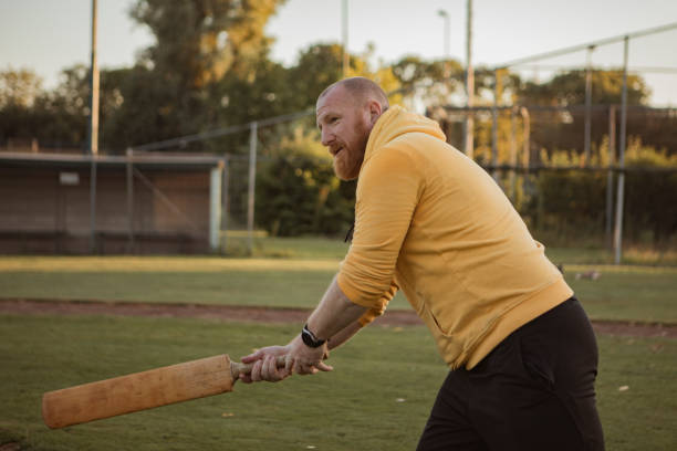 istock Overweight middle aged man on a pitch with a cricket bat 1414610703