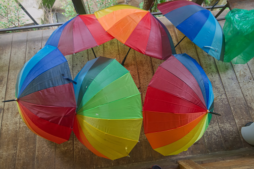 Colorful rainbow umbrella group on wooden floor in a house