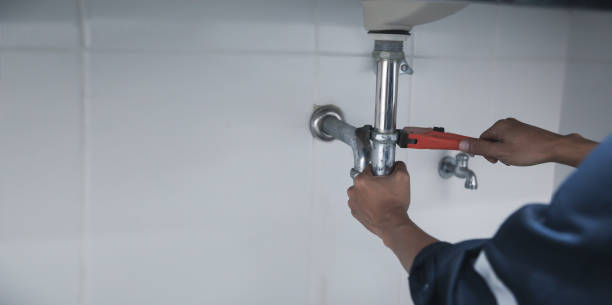 istock Male Plumber Using Wrench To Fix Leaking Sink In Home Bathroom. 1414612755