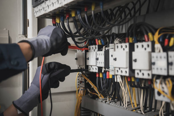 istock Electricity and electrical maintenance service, Engineer hand holding AC multimeter checking electric current voltage at circuit breaker terminal and cable wiring main power distribution board. 1414613239