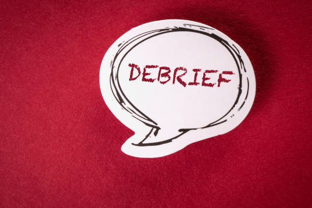DEBRIEF. Text on speech bubble and red background stock photo