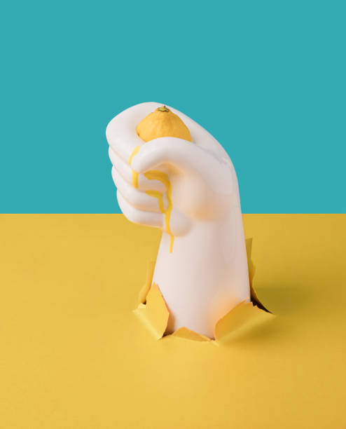 istock Concrete hand squeezing lemon with yellow juice dripping. 1414617384