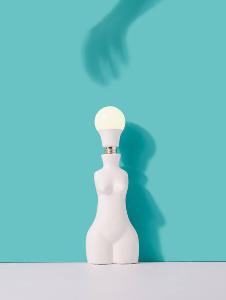 istock Light bulb in a human shaped vase with hand shadow reaching. 1414617509