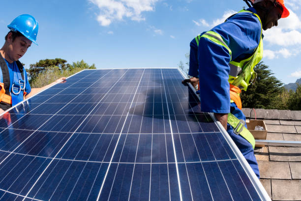 istock Close up solar panel carried by workers on roof 1414618880
