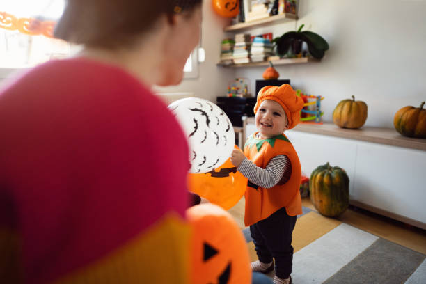 mama i mały syn bawiący się balonami podczas halloween - house halloween autumn candid zdjęcia i obrazy z banku zdjęć