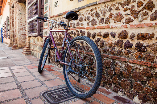 Bicycle parked next to an ancient stone wall at the colonial town of Santa Fe de Antioquia in Colombia