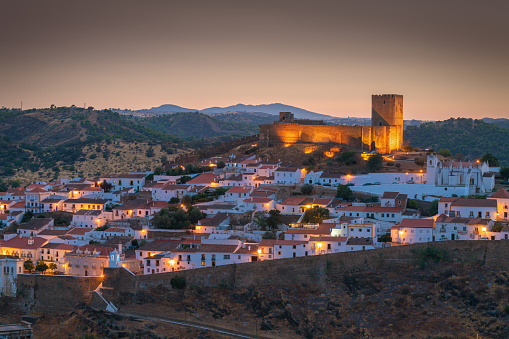 Mértola old town, with the old Catholic church, after dusk.  Mértola is a municipality in southeastern Portuguese Alentejo near the Spanish border. It is famous for the mediaeval fortress (seen on the center left) and walls, that surround the old town. The photo is digitally edited for colour.