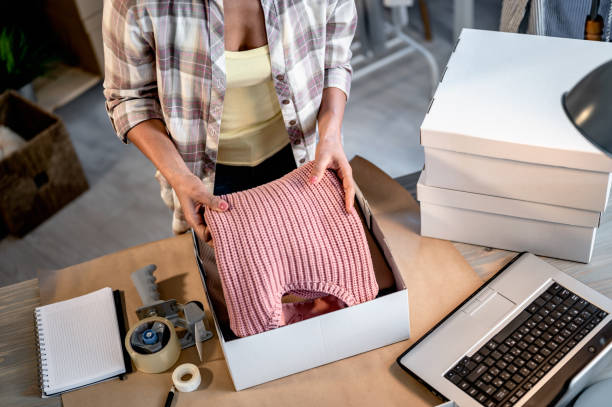 istock Young smiling entrepreneur woman working in her small workshop packing a merchandise to send it to online buyers. 1414625383
