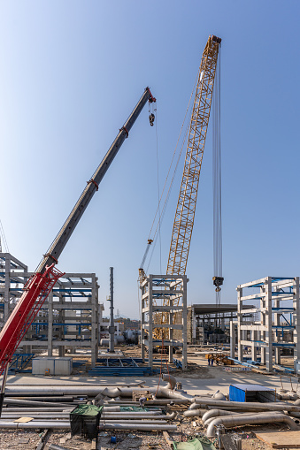 Cranes and other mechanical equipment at the construction site of new chemical plant