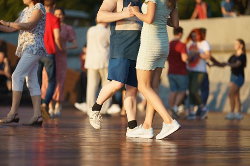 Moscow, Russia, July 24, 2022, Cheerful Dancing couples of young man and woman in public park. Lifestyle theme. Having fun people. Low angle view