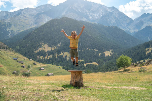 istock Child jumping for joy in a majestic mountainous landscape 1414629761