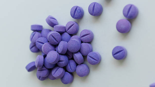 istock Scattered blue pills on a white background. Dental plaque detection tool 1414633416