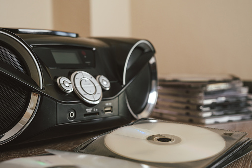 CD player, two speaker tape recorder. Black color. Inside the house. Many CDs and containers around. still life shooting