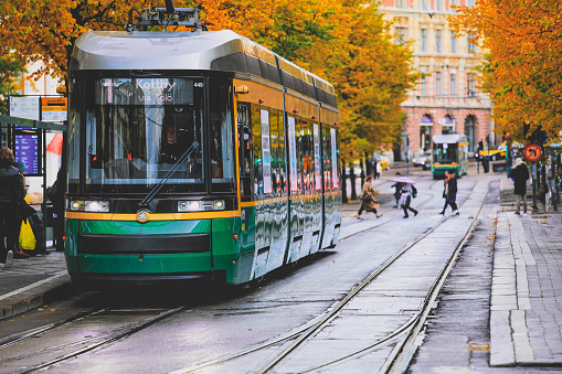 Helsinki, Finland - October 5, 2019 : Green tram transporting people in the central part of the Helsinki city during autumn  season, Finland