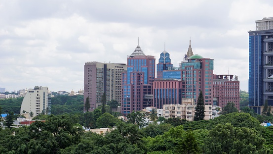Bangalore,Karnataka,India-June 19 2022: View of Bangalore cityscape from terrace of Chancery Pavilion Hotel. Stadium and skyscrapers such as Prestige UB City Concorde Block visible through green cover.