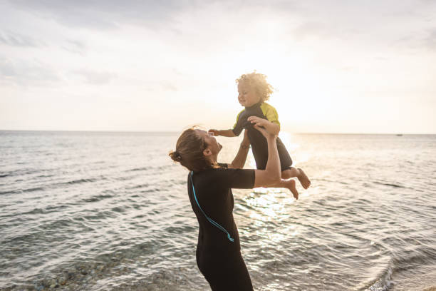 istock Surfer mum with her boy at the beach 1414638327