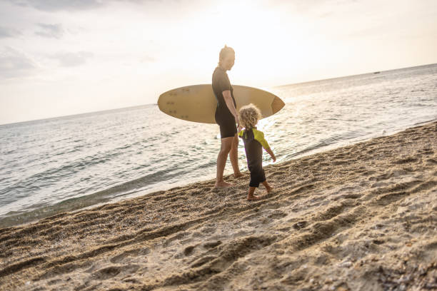 istock Little surfer and his mom at the beach 1414638337