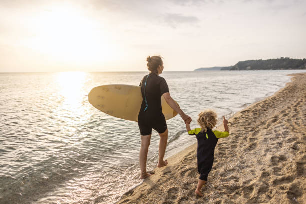 istock Little surfer and his mom at the beach 1414638355