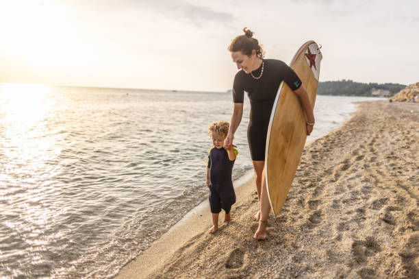 istock Little surfer and his mom at the beach 1414638477