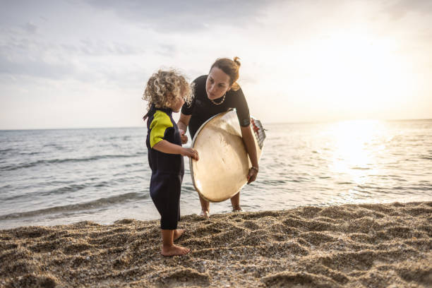 istock Surfing mum and son leave the water together 1414638597