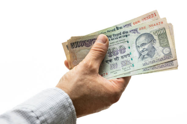 istock Indian rupees, bundle of money, held in hand on a light background 1414638858