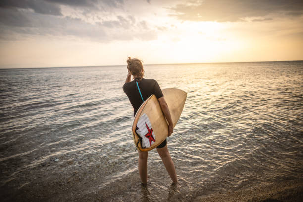 istock Woman surfer with surfboard at the beach 1414638972
