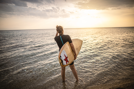 Photo of woman surfer with surfboard at the beach