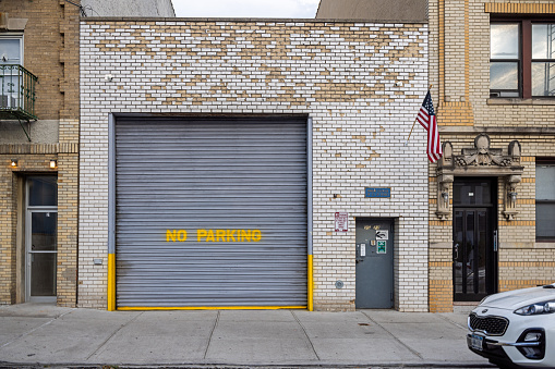 Long Island City, Queens, New York, NY, USA - July 5th 2022: Garage with a no parking notice painted on the gate