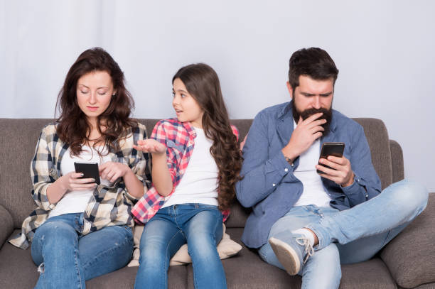istock Mobile device affecting relationship. Unhappy kid complain at parents using phones. Smartphone addicts. Family relationship problem. Parents and child relationship. Dealing with unhappy relationship 1414648160