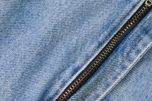 Denim blue jeans texture background with closed zipper