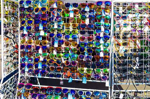 Two friends hanging out in local market checking local stalls to buy sunglasses in Chinatown, Kuala Lumpur, Malaysia.