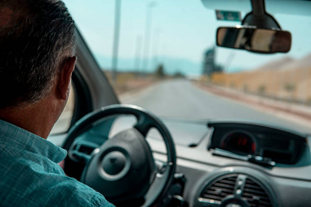 istock Caucasian man driving a car on the road. 1414650491