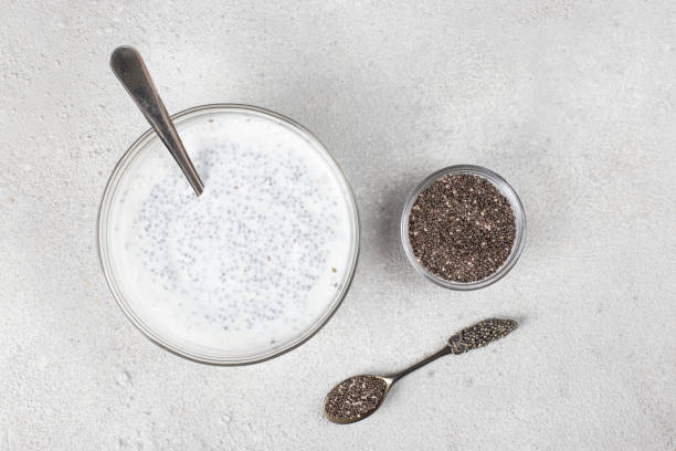 Chia seeds and natural yogurt for making pudding on a gray background, Top view stock photo