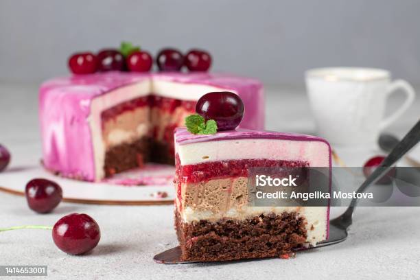 Piece Of Mousse Cake With Chocolate Biscuit Vanilla And Cream Mousse Cherry Confit And Milk Chocolate Ganache Stock Photo - Download Image Now